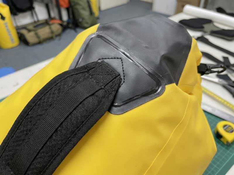Shoulder strap sewn to a reinforcing patch that is welded to a dry bag backpack body
